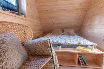 a bed in a wooden room with a table and a bench at Solankowe Zacisze Żmiąca in Żmiąca