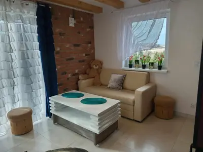a living room with a couch and a table at Domek pod lasem in Toporzysko