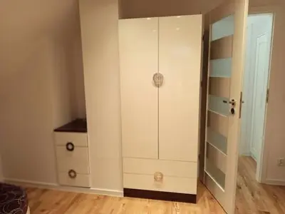 a white closet with a dresser in a room at Domek pod lasem in Toporzysko