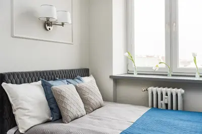 a bedroom with a bed with pillows and a window at Silver Suite Old Town Apartament in Kraków
