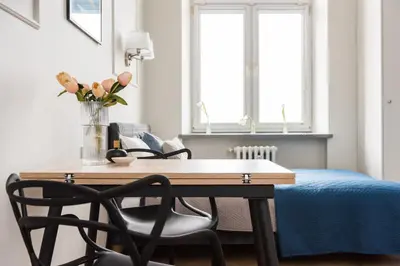 a dining room table with chairs and a vase with flowers at Silver Suite Old Town Apartament in Kraków