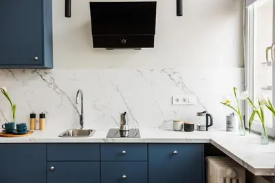 a kitchen with blue cabinets and a sink at Azure Haven Old Town Apartament in Kraków