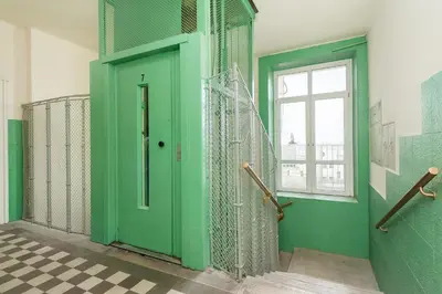 a green door in a room with a checkered floor at Azure Haven Old Town Apartament in Kraków
