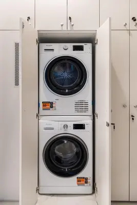 a washer and dryer in a white room at Azure Haven Old Town Apartament in Kraków