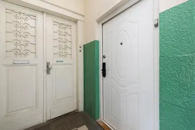 two white doors in a room with green walls at Azure Haven Old Town Apartament in Kraków