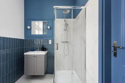 a bathroom with a shower with a toilet and a sink at Azure Haven Old Town Apartament in Kraków