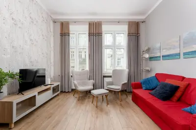 a living room with a red couch and a tv at Starowiślna 38 Charming Apartment by BookingHost in Kraków
