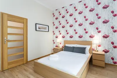a bedroom with a bed and a floral wallpaper at Starowiślna 38 Charming Apartment by BookingHost in Kraków