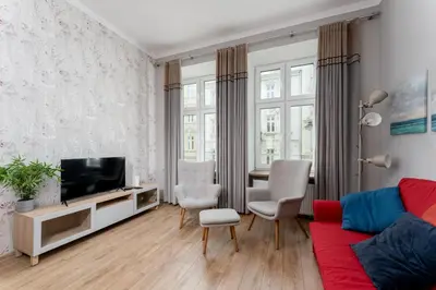 a living room with a couch and a tv at Starowiślna 38 Charming Apartment by BookingHost in Kraków