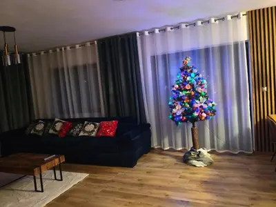 a christmas tree in a living room with a blue couch at Willa Sielski Zakątek in Raba Wyżna