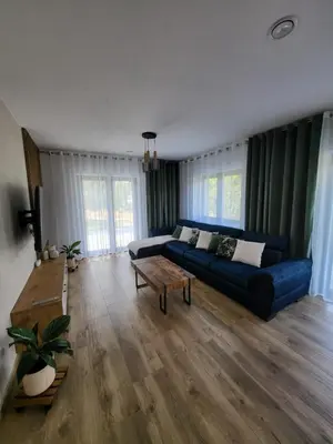 a living room with a blue couch and a table at Willa Sielski Zakątek in Raba Wyżna