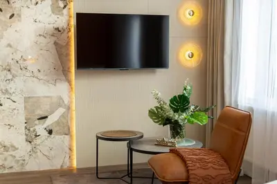 a living room with a table and a television on a wall at Heritage Apartments in Kraków