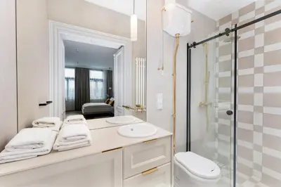 a bathroom with a sink and a toilet and a mirror at Heritage Apartments in Kraków