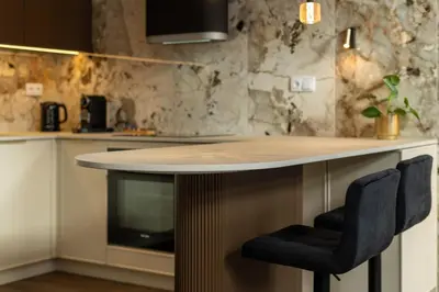 a kitchen with a counter with two chairs around it at Heritage Apartments in Kraków
