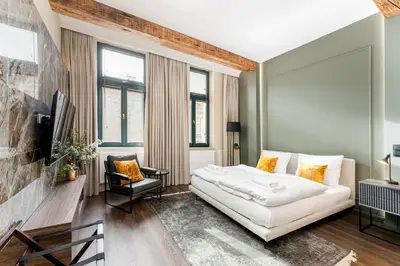a living room with a white couch and a tv at Heritage Apartments in Kraków