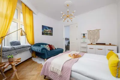 a bedroom with a bed and a blue chair at Słoneczny Apartament 2 Sypialnie, Biurko & Klimatyzacja by Rent like home in Kraków
