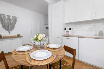 a kitchen with a wooden table with plates on it at Słoneczny Apartament 2 Sypialnie, Biurko & Klimatyzacja by Rent like home in Kraków