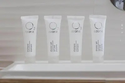 a shelf with four bottles of cream in a refrigerator at Słoneczny Apartament 2 Sypialnie, Biurko & Klimatyzacja by Rent like home in Kraków