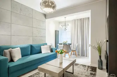 a living room with a blue couch and a table at Apartment Cracow Wawrzyńca by Noclegi Renters in Kraków