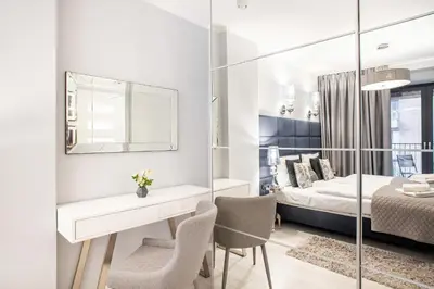 a bedroom with a bed and a desk and chairs at Apartment Cracow Wawrzyńca by Noclegi Renters in Kraków