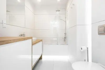 a white bathroom with a shower and a toilet at Apartment Cracow Wawrzyńca by Noclegi Renters in Kraków