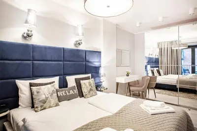 a bedroom with a large bed with a blue headboard at Apartment Cracow Wawrzyńca by Noclegi Renters in Kraków