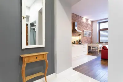 a kitchen with a table and a mirror on a wall at Apartamenty Łazarza 17 in Kraków