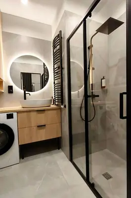 a bathroom with a shower and a sink and a mirror at Apartamenty Łazarza 17 in Kraków