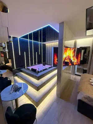 a living room with a fireplace and a fire pit at Wiślane Tarasy 2 VIP Apartamenty JACUZZI in Kraków