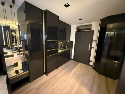a kitchen with black walls and a wooden floor at Wiślane Tarasy 2 VIP Apartamenty JACUZZI in Kraków