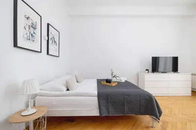 a white bedroom with a bed and a tv at Apartament w Sercu Krakowa z Dwoma Sypialniami by Rent like home in Kraków
