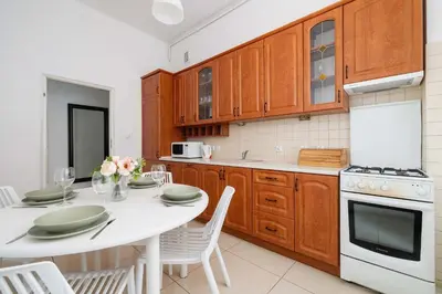a kitchen with a white table and a white appliance at Apartament w Sercu Krakowa z Dwoma Sypialniami by Rent like home in Kraków