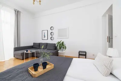 a white bedroom with a bed and a couch at Apartament w Sercu Krakowa z Dwoma Sypialniami by Rent like home in Kraków