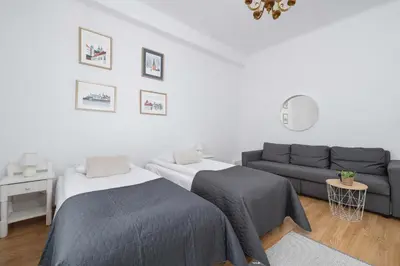 a living room with two beds and a couch at Apartament w Sercu Krakowa z Dwoma Sypialniami by Rent like home in Kraków