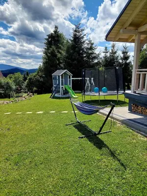 a hammock sitting on the grass in a yard at Plutowka in Zawoja