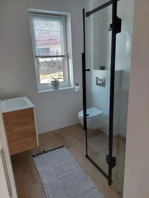 a bathroom with a shower and a toilet and a window at Plutowka in Zawoja