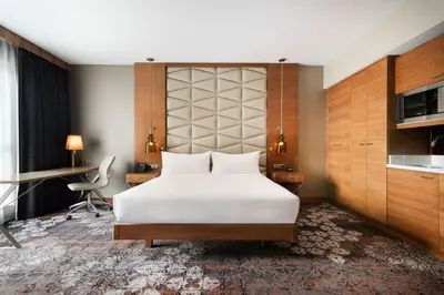a bedroom with a large white bed and a desk at DoubleTree by Hilton Krakow Hotel & Convention Center in Kraków