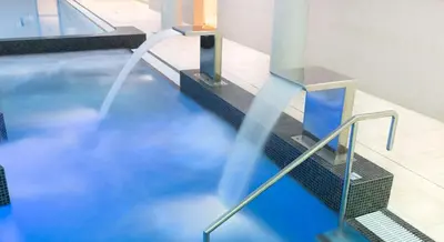 a swimming pool with a fountain in a building at DoubleTree by Hilton Krakow Hotel & Convention Center in Kraków