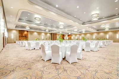 a large banquet hall with white tables and white chairs at DoubleTree by Hilton Krakow Hotel & Convention Center in Kraków