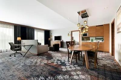 a dining room and living room with a table and chairs at DoubleTree by Hilton Krakow Hotel & Convention Center in Kraków
