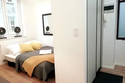 a bedroom with a bed with yellow pillows at Skawińska Street Apt in Kraków