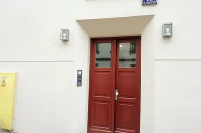 a red door on the side of a white building at Skawińska Street Apt in Kraków