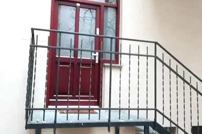 a staircase with a red door and a red window at Skawińska Street Apt in Kraków