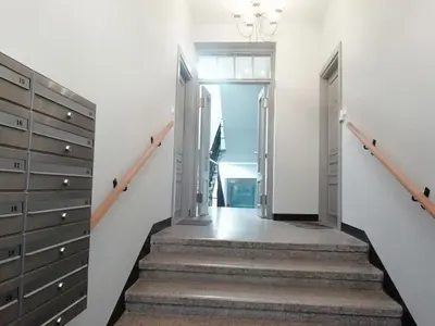 a staircase leading to a room with white walls at Skawińska Street Apt in Kraków