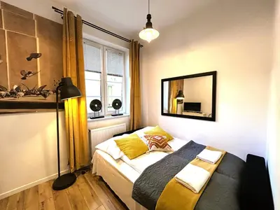 a bedroom with a bed and a mirror on the wall at Skawińska Street Apt in Kraków
