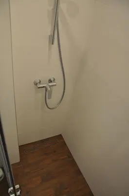 a shower in a white wall with a hose at Willa Relaks in Wieliczka