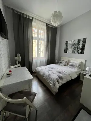 a bedroom with a bed and a table and a window at AMETYST Apartment in Kraków