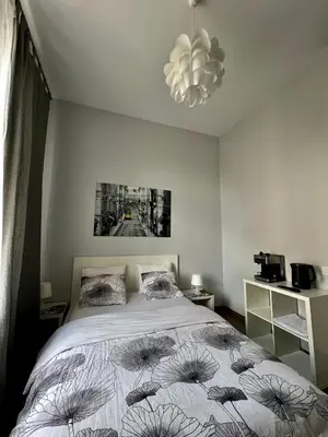 a bedroom with a bed and a chandelier at AMETYST Apartment in Kraków