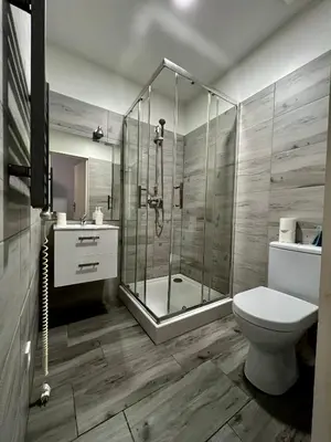 a bathroom with a shower and a toilet and a sink at AMETYST Apartment in Kraków