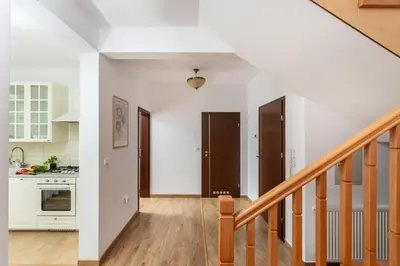 a kitchen with white walls and wooden floors and a staircase at Your private oasis in Cracow in Kraków